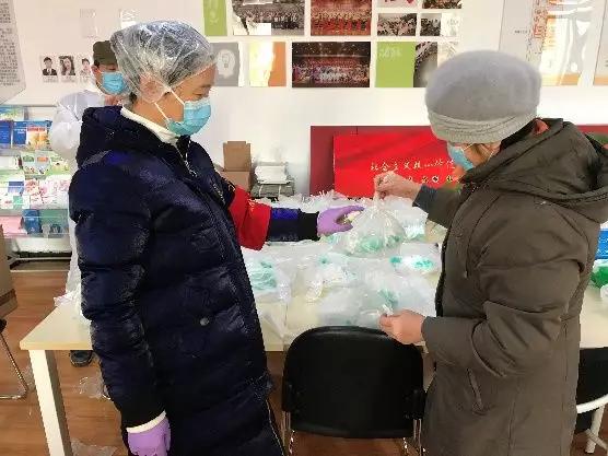 為樓棟分發(fā)口罩，并為包裝袋消毒